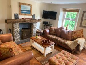 a living room with couches and a fireplace at Clotted Cream Cottage: Countryside calm: Close to beach: Dartmouth: Devon in Dartmouth