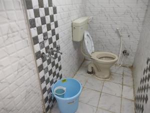 a bathroom with a toilet and a trash can at Hotel Karthikeya Residency in Kākināda