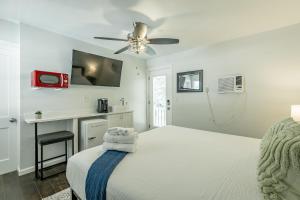 a white bedroom with a bed with a ceiling fan at 13 The Eero Room - A PMI Scenic City Vacation Rental in Chattanooga