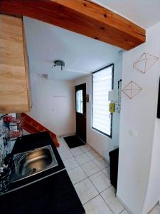 una pequeña cocina con fregadero y ventana en Le Passage Secret, en Saint-Omer