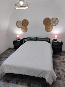 1 dormitorio con 1 cama blanca grande y 2 mesitas de noche en Le Passage Secret, en Saint-Omer