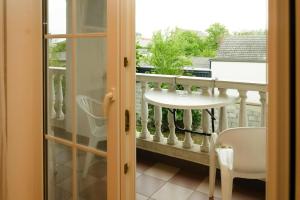 Zimmer mit einem Balkon mit einem Tisch und einem Fenster in der Unterkunft Apartment in Podersdorf am See with a bicycle storage in Podersdorf am See