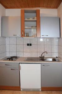 eine Küche mit weißen Schränken und einem Waschbecken in der Unterkunft Apartment in Podersdorf am See with a bicycle storage in Podersdorf am See