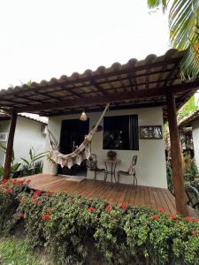 una terraza de madera con mesa y sillas en una casa en Pousada Villa Mares, en Barra Grande