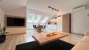 ein Wohnzimmer mit einem Holztisch und einer Küche in der Unterkunft Dom - Apartamenty Prestige - opcja jacuzzi i sauna in Solina