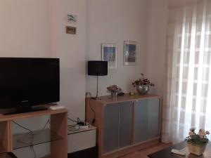 a living room with a flat screen tv on a stand at Amanecer marino, solo a 5 minutos andando de la playa in Puzol
