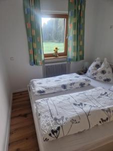 two beds in a bedroom with a window at Oase der Ruhe in Hollersbach im Pinzgau