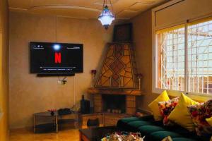 a living room with a tv and a couch and a fireplace at Magnifique Villa tout confort proche du Centre-ville in Oujda