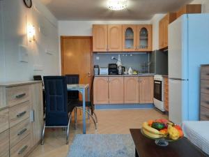 a kitchen with a table and a white refrigerator at Cosy Breeze Apartment in Varna City