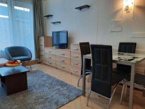 a living room with a table and chairs and a television at Cosy Breeze Apartment in Varna City