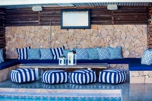 un banc avec des oreillers bleus et blancs et une table dans l'établissement Rambutan Resort, à Townsville