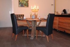uma mesa de jantar com duas cadeiras pretas e uma mesa em Di'Mami House em Avenhorn