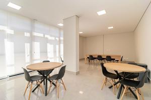 una sala de reuniones con 2 mesas y sillas en CWBe Residencial, en Curitiba