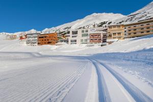 a street covered in snow with buildings in the background at Apartment in Obergurgl in the mountains in Obergurgl