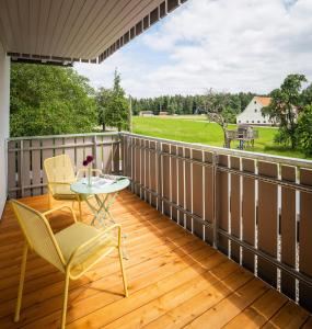 a patio with a table and chairs on a wooden deck at Hotel Sonnenhof Teinachtal in Neuweiler