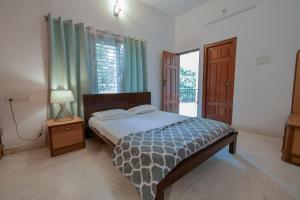 um quarto com uma cama, um candeeiro e uma janela em HomeSlice Hangout em Bangalore