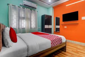 sypialnia z łóżkiem i telewizorem z płaskim ekranem w obiekcie OYO Flagship S Grand Residency w mieście Hajdarabad