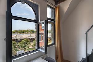 an open window with a view of a building at Charming Two-Bedroom River Side Apartment in Antwerp