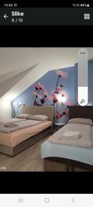 a room with two beds and a wall with flowers at Apartman Ananas Banja Luka centar bolnica besplatan parking in Banja Luka