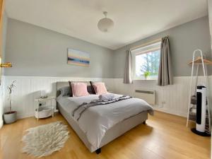 a bedroom with a bed with pink pillows and a window at Homestead Cottage, Fort Augustus in Fort Augustus
