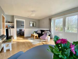 a living room with a couch and a pink chair at Homestead Cottage, Fort Augustus in Fort Augustus