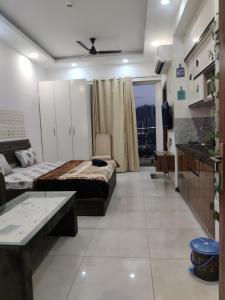 Habitación grande con 2 camas y mesa. en The Forest Stays-Luxury Studio Apartment In Noida en Noida