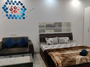 1 dormitorio con cama, sofá y reloj en The Forest Stays-Luxury Studio Apartment In Noida en Noida