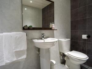 a bathroom with a toilet and a sink and a mirror at My Way Guest House in Durham