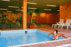 a woman laying in a swimming pool at Apartments Sonnenresort Maltschacher See, Feldkirchen in Feldkirchen in Kärnten