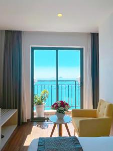 a living room with a large window with a view of the ocean at Putin Hotel Nha Trang in Nha Trang
