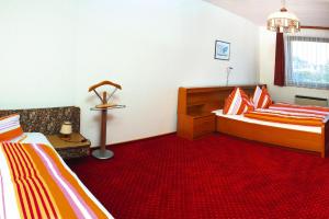 a bedroom with two beds and a red carpet at Apartment in St Kanzian 800 m from the lake in Srejach