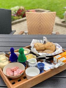 een dienblad met brood en ander voedsel op een tafel bij Central by lejlighed in Nykøbing Falster