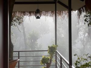 ein Fenster eines Hauses mit einer Pflanze auf einem Balkon in der Unterkunft Coffee Cradle Wayanad Luxuorios Private Tree House - Inside 2 Acre Coffee Plantation in Mananthavady