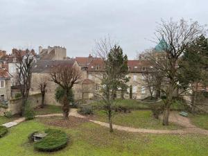 a group of trees in front of a building at Le Tivoli - Balcon Vue jardin in Dijon