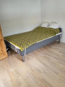 a bed in a room with a wooden floor at Hyggelig lejlighed i Sandavágur in Sandavágur