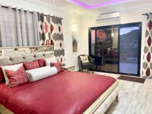 Un dormitorio con una gran cama roja y una ventana en After 5 Apartment 3 2 spacious en-suite bedrooms, en Freetown