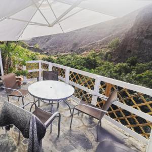 una mesa y sillas en un balcón con vistas en Eco Finca in Paradise Valley Azuaje, en Firgas