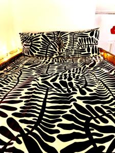 a black and white zebra print bed in a bedroom at Cozy nest in the heart of Helsinki in Helsinki