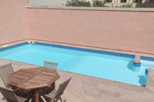 a swimming pool with a table and chairs next to it at Home away from Home in Żurrieq