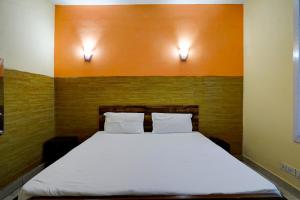 a bed in a room with two lights on the wall at OYO Home The Heaven Guest House in Noida
