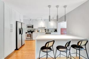 una cucina con bancone bianco e sedie nere di Idyllic Boca Pool Home: 4/2.5 + Study-FAU & Mizner a Boca Raton