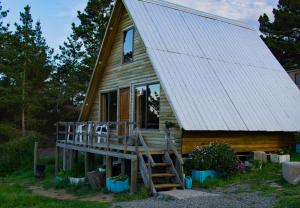 Cabaña de madera con porche y ventana en Vista Hermosa Laguna Verde, en Laguna Verde