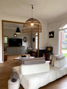 uma sala de estar com um sofá branco e uma mesa em La Villa Lumaga em Étretat