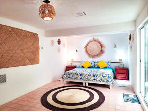 a bedroom with a bed and a rug on the floor at Casa Isabella in Cozumel