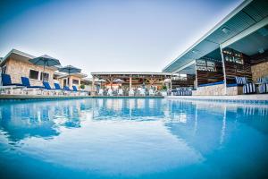 a swimming pool with blue chairs and a building at Rambutan Resort in Townsville