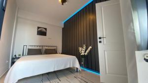 - une chambre avec un lit blanc et une lumière bleue dans l'établissement Q Luxury Apartment - Palas Center, à Iaşi