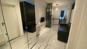 - un salon avec un fauteuil en cuir noir dans l'établissement Q Luxury Apartment - Palas Center, à Iaşi