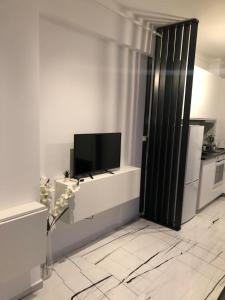 Habitación con puerta y TV en la pared en Q Luxury Apartment - Palas Center, en Iaşi 4 fotos más