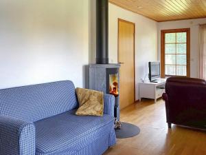 a living room with a blue couch and a fireplace at Holiday home BENGTSFORS VI in Bengtsfors