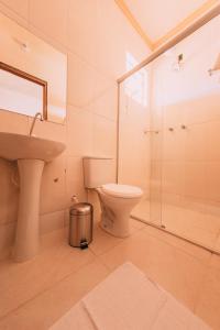 y baño con aseo, lavabo y ducha. en POUSADA ELMIRA´S BELA VISTA, en Ouro Branco